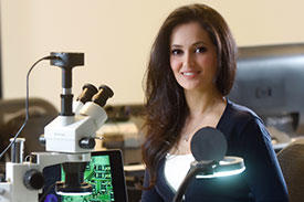 Sahar Mazloom at desk with microscope and computer. 