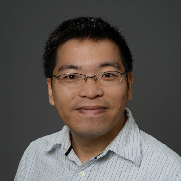 Edward Huang wears glasses and light, striped shirt in his faculty profile for the SEOR department at George Mason University