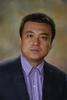 Bo Liu is wearing a purple, button-down shirt and black suit jacket for his faculty profile at George Mason University.