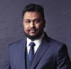 Mason assistant professor Isuru Dassanayake wears a blue suit and tie in his faculty profile