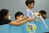 Middle school kids testing their robotic devices in a water tank at the SeaPerch summer camp