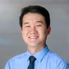 Mason bioengineering assistant professor Eugene Kim wears a light-blue shirt, navy blue tie and smiles in his faculty profile