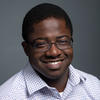 Mason assistant professor Tokunbo Fadahunsi wears a blue shirt and glasses in his faculty profile