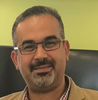 CYSE Assistant Professor Mohamed Gebril wears a tan shirt and glasses in his faculty profile at GMU