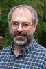 Robert Simon a blue, plaid shirt and glasses in his faculty profile for the Department of Computer Science at George Mason University