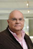 Mason professor Daniel Barbara wears a brown jacket, pink shirt, glasses and has a bald head in his profile